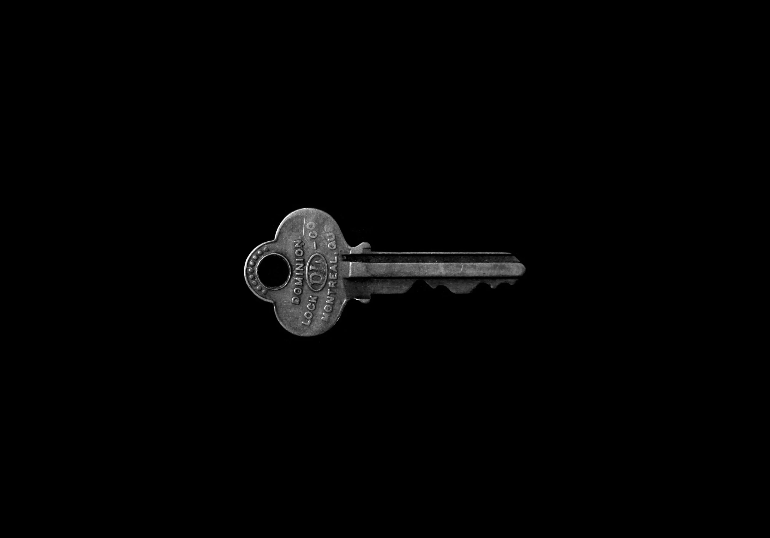 Silver key on a black background