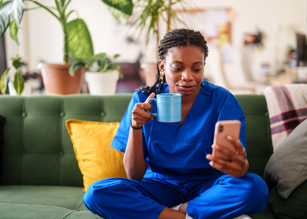 Woman enjoying a coffee break while using her mobile device