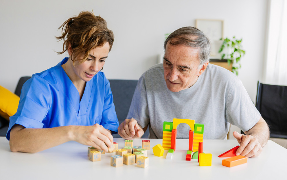 Caregiver helping elderly with a puzzle